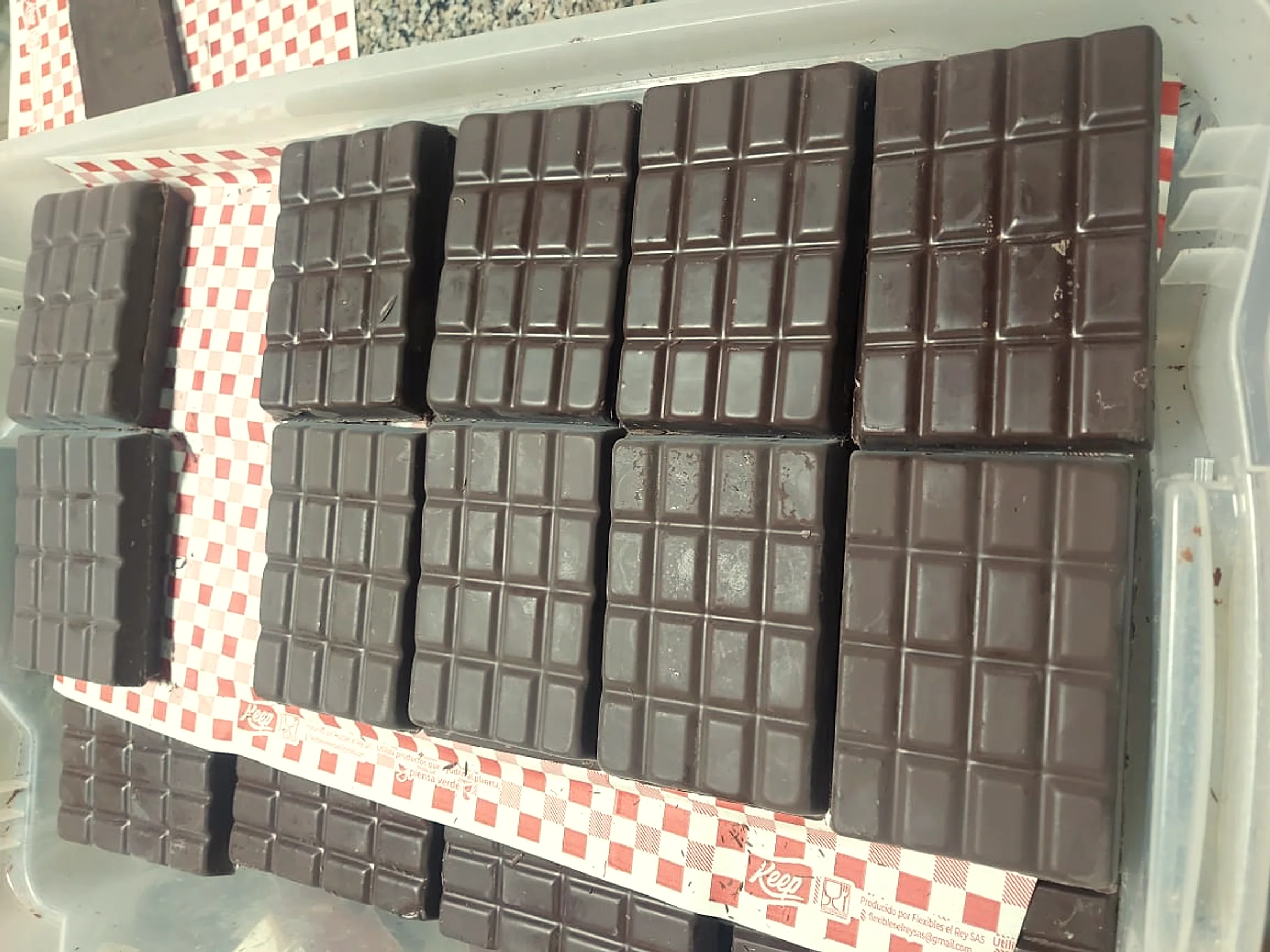Production-scale stacked dark chocolate bars made from FLZ-03 cacao, on the family farm.