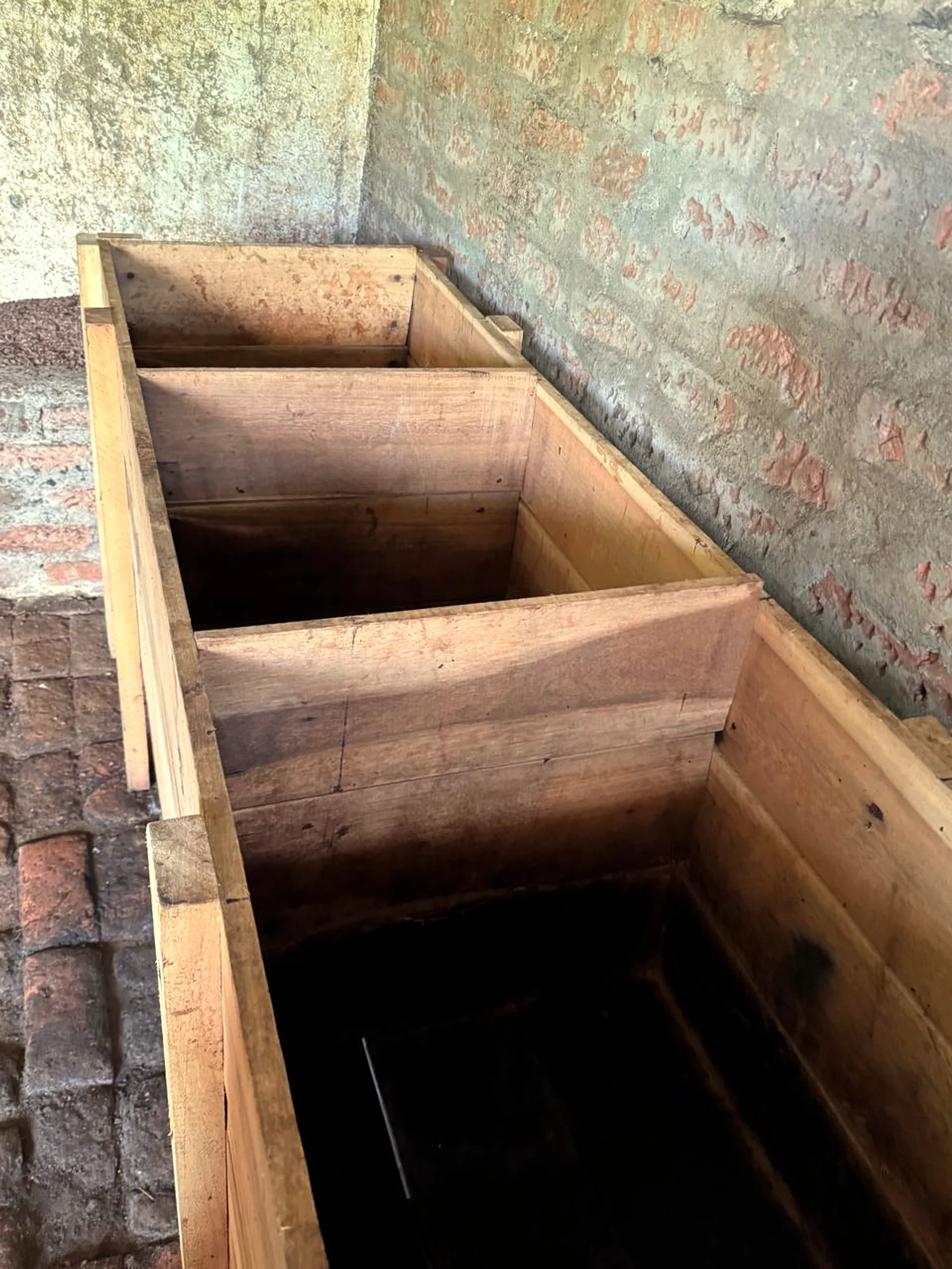 The empty fermentation room at Finca La Tesalia between harvests — clean wooden boxes, banana leaves stacked, waiting.